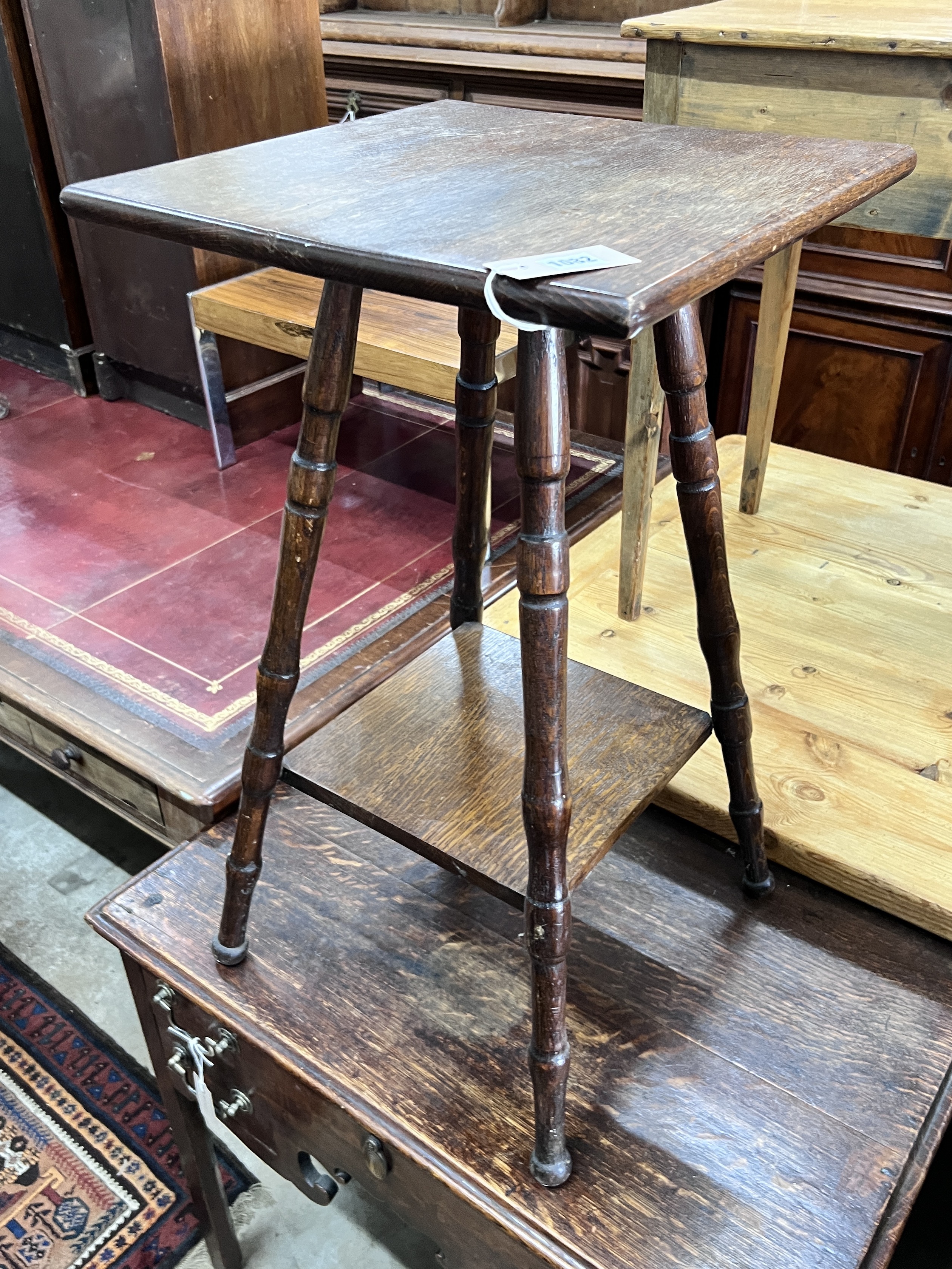 An early 20th century two tier oak occasional table, width 40cm, height 72cm